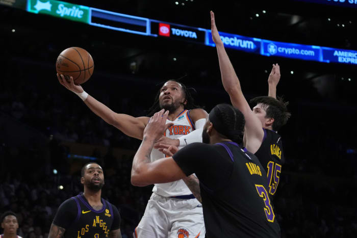 Dec 18, 2023; Los Angeles, California, USA; New York Knicks guard Immanuel Quickley (5) shoots the ball against Los Angeles Lakers guard D'Angelo Russell (1), forward Anthony Davis (3) and guard Austin Reaves (15) in the first half at Crypto.com Arena.